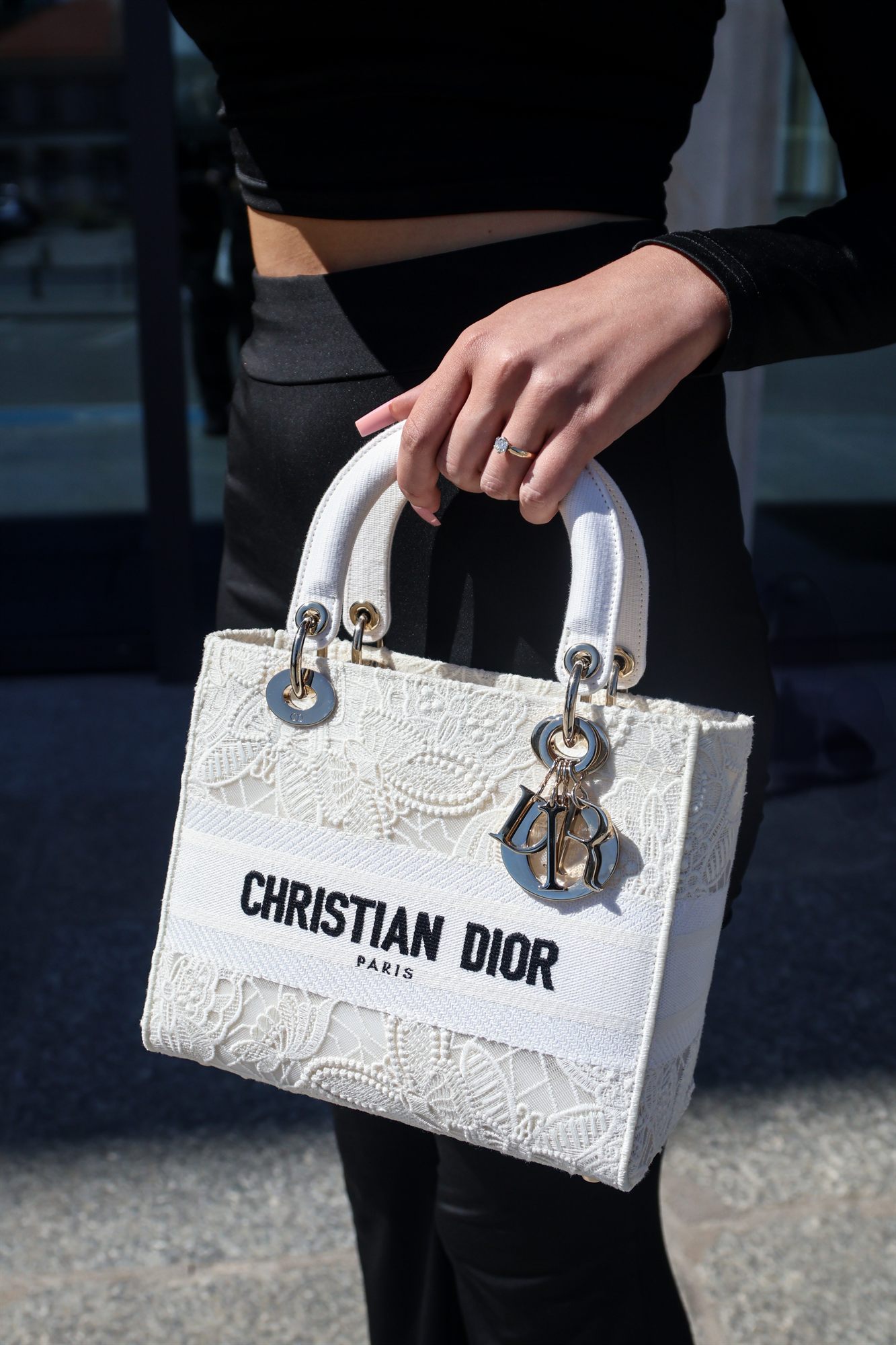 Biała torebka Lady Dior w dłoni