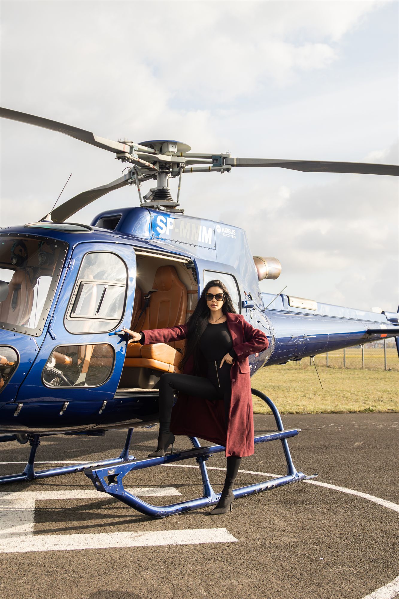 Kobieta w czerwonym płaszczu przy helikopterze